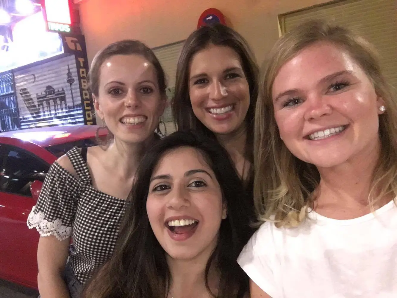 Group of friends smiling together in Madrid during night out