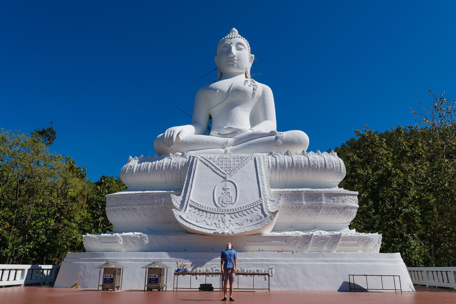 Large white Buddha statue in Thailand with blue sky background