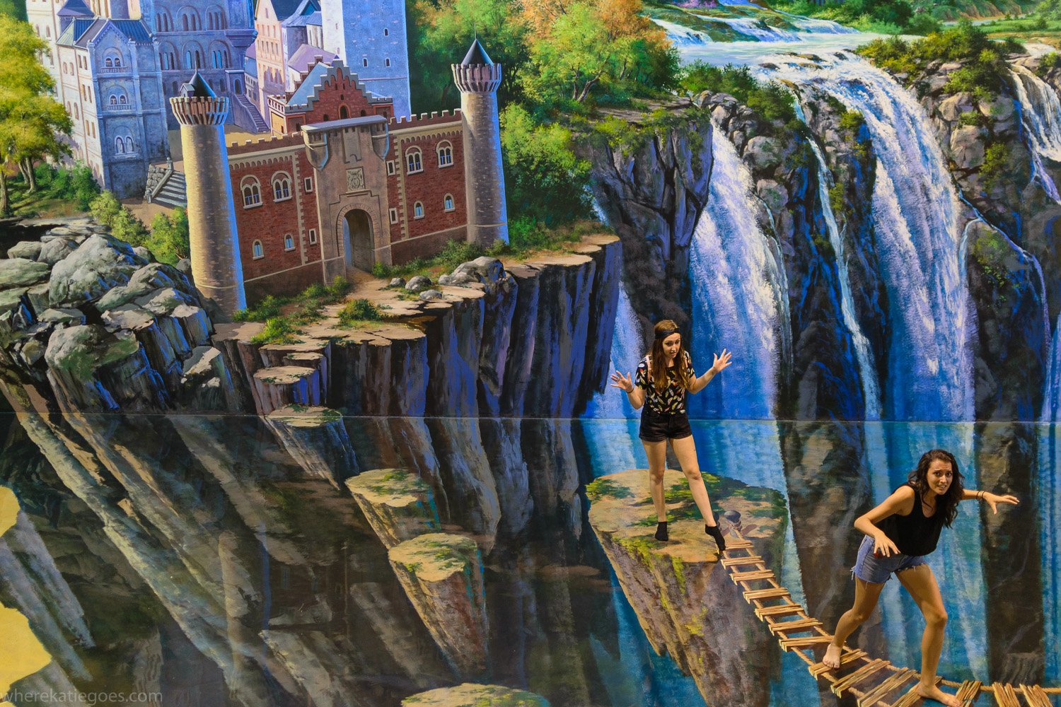 Tourists posing on 3D waterfall illusion artwork
