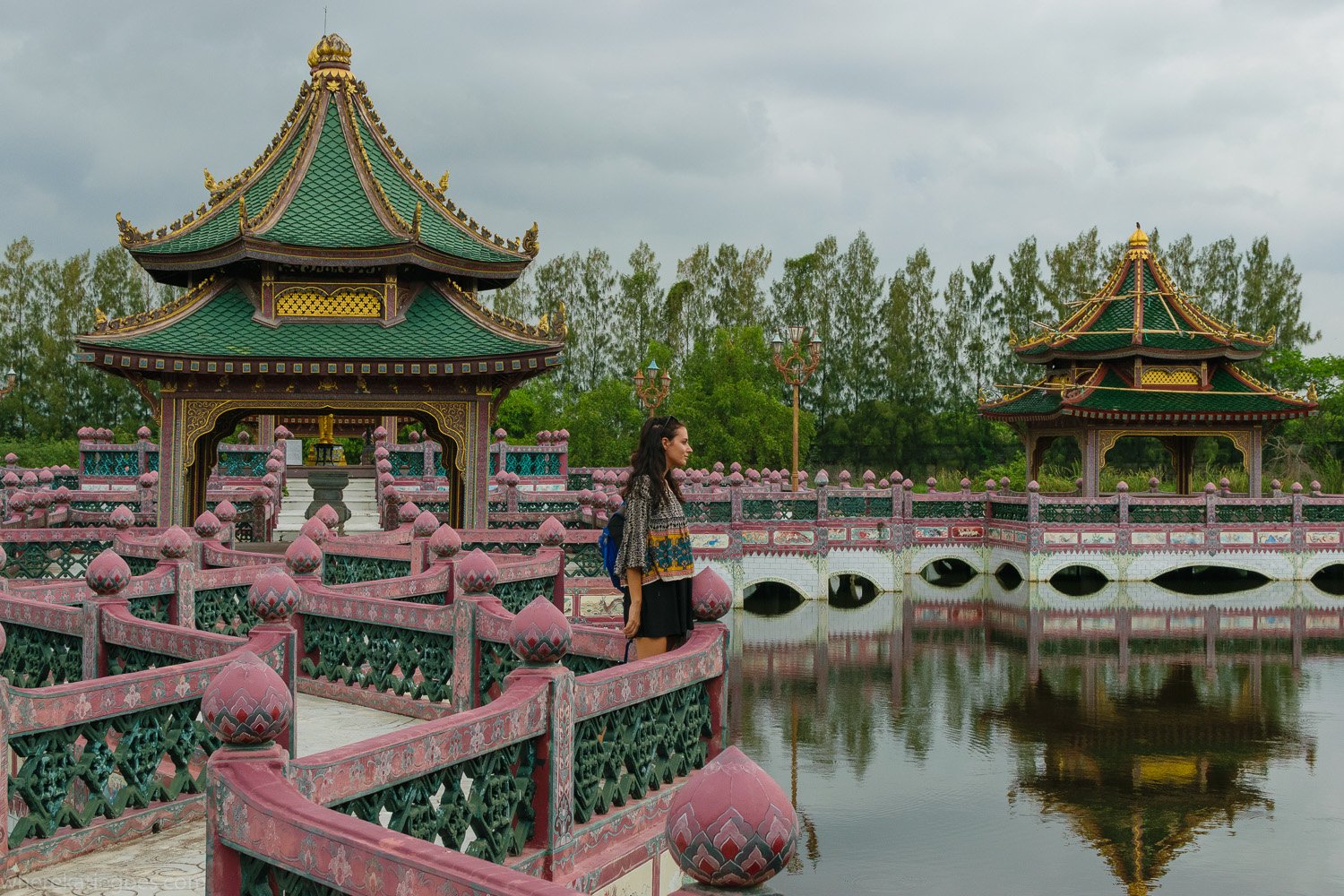 Traditional Thai temple and bridge with reflection in water