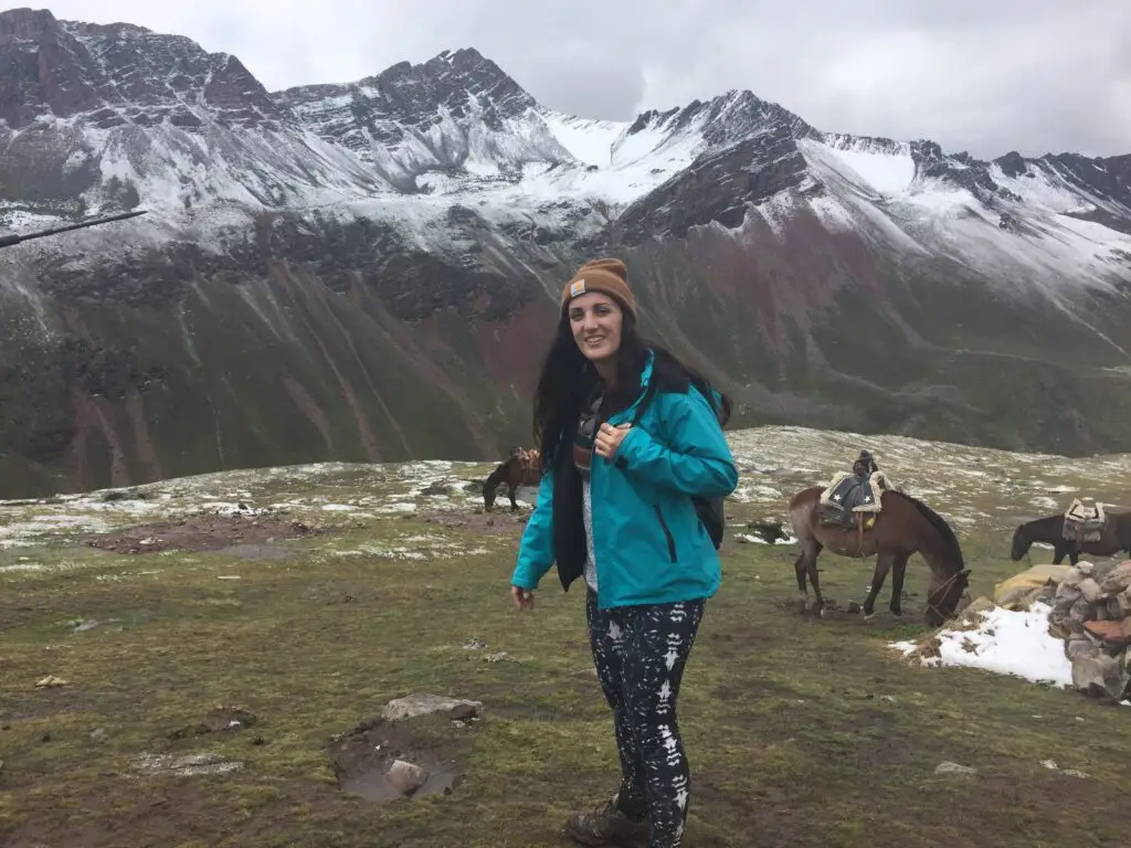 Woman standing in mountain landscape in Peru with snow-capped peaks