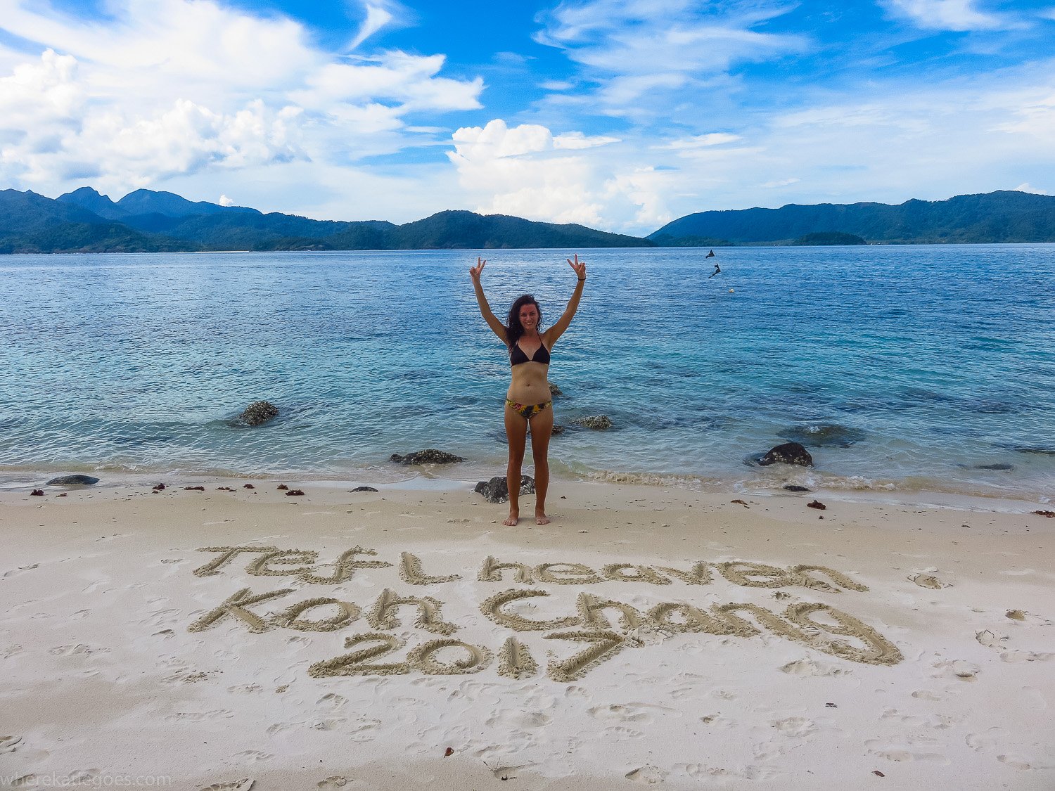 Woman on beach in Thailand with “TEFL Heaven Koh Chang 2017” written in sand