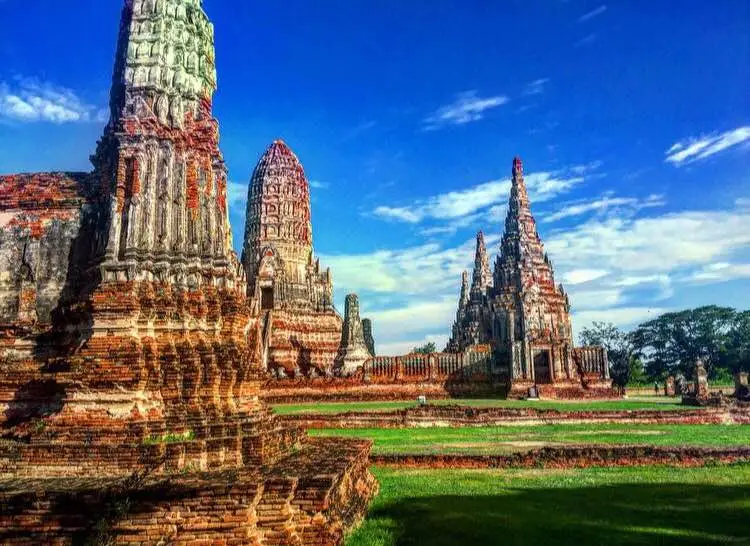 Ancient temple ruins in Ayutthaya with historic brick structures under blue sky