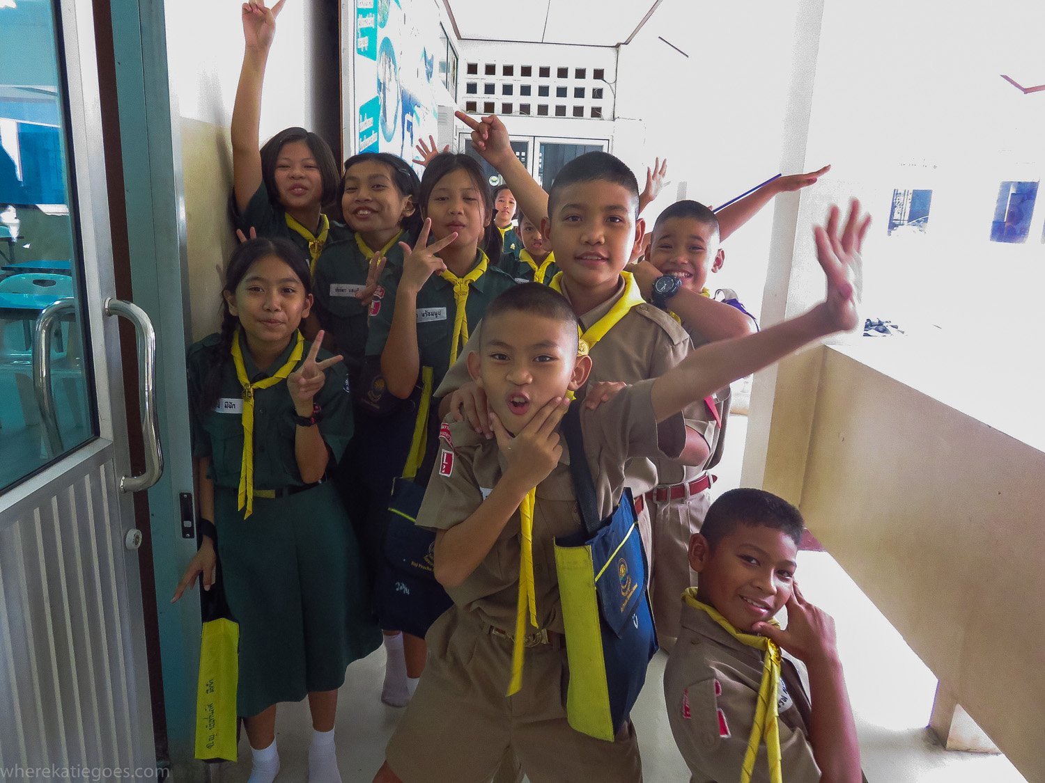 School children in Thailand smiling and posing in classroom corridor