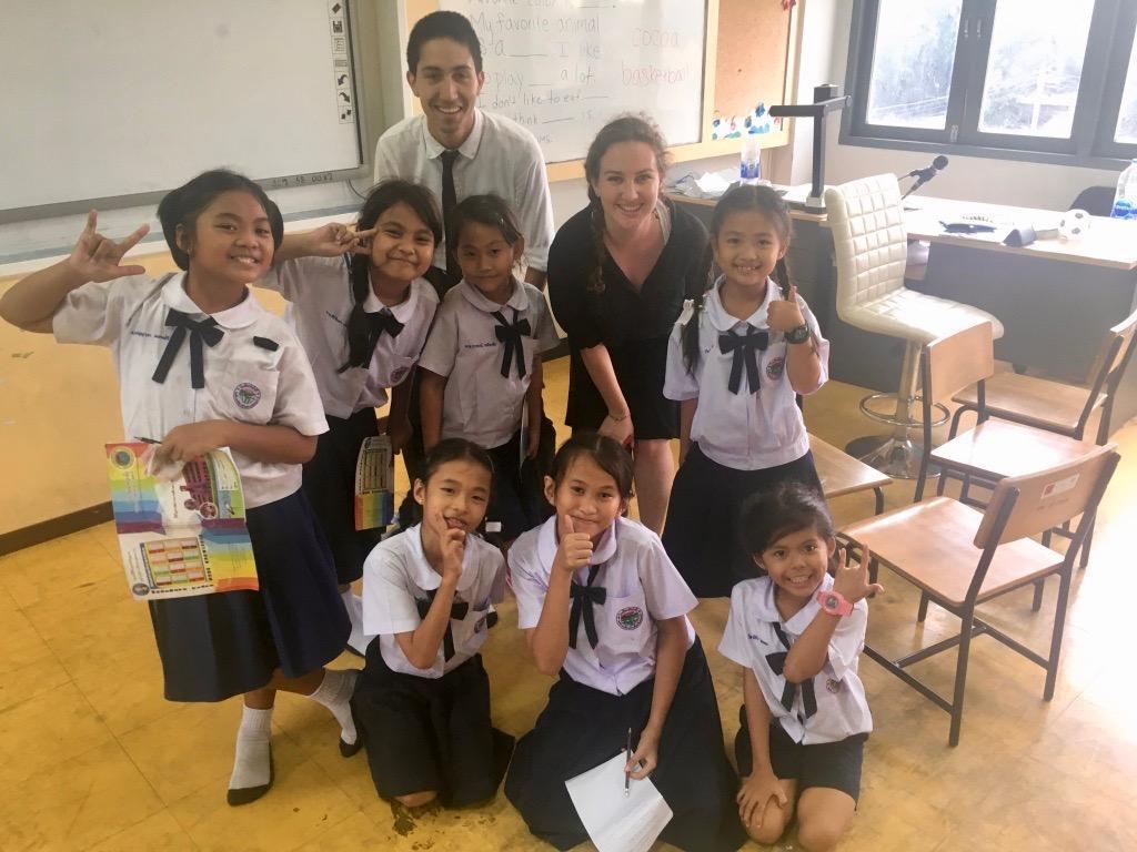 Teacher posing with schoolchildren in a classroom in Thailand