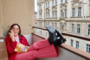 Woman relaxing on a balcony with snacks in Prague