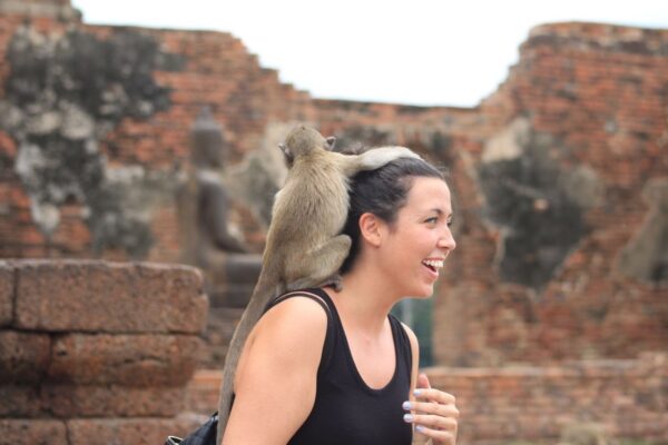 Woman with monkey in Thailand during travel and teaching abroad experience